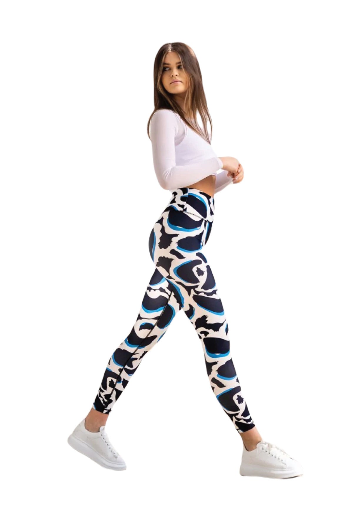 Frau in einem weißen Oberteil trägt Lismina 1188 High Waist Leggings in Blau, Weiß und Schwarz mit weißen Sneakers auf schlichtem Hintergrund.